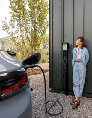 Femme qui attend que son véhicule électrique charge