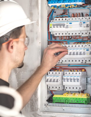 Homme qui manipule un tableau électrique