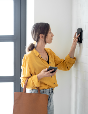 Femme entre un code sur le clavier d'alarme à la maison