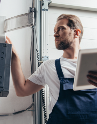 homme avec tablette numérique vérifiant la boîte électrique