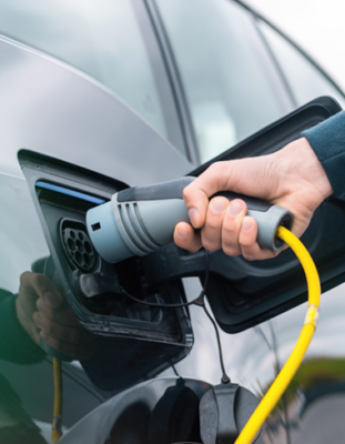 Homme rechargeant une voiture électrique